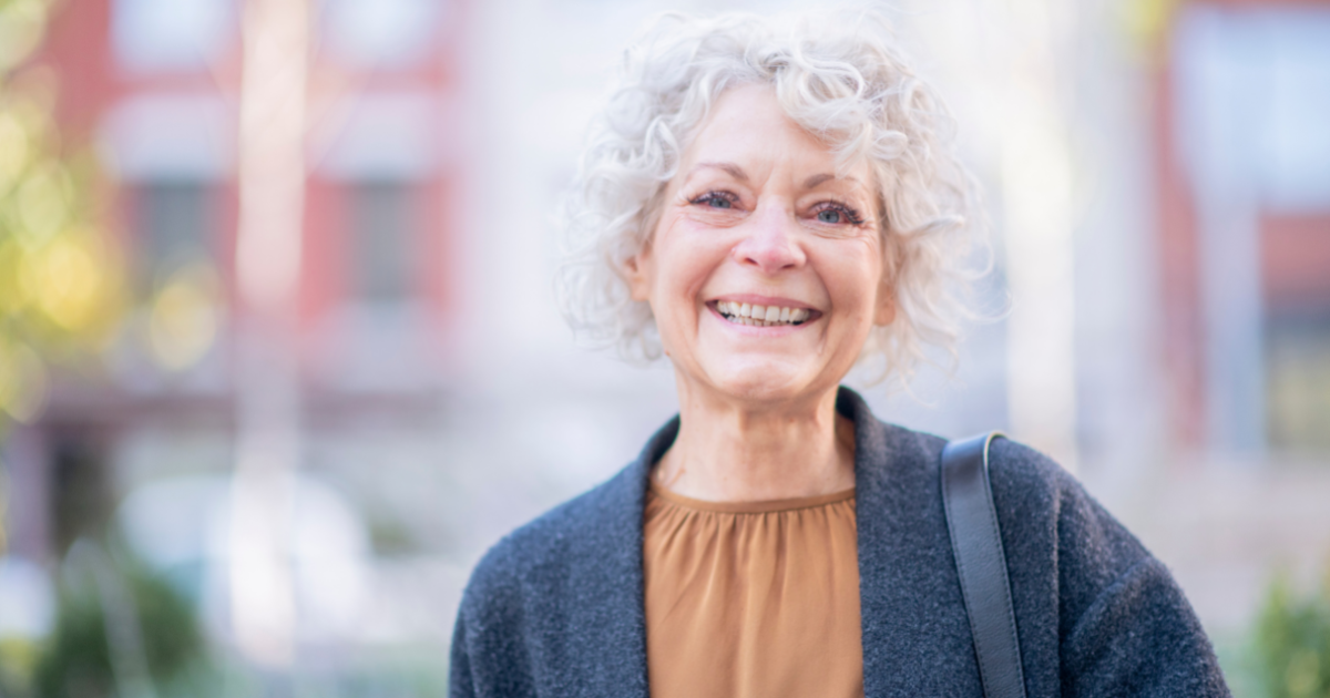 A woman is confident and happy despite dealing with senior incontinence.